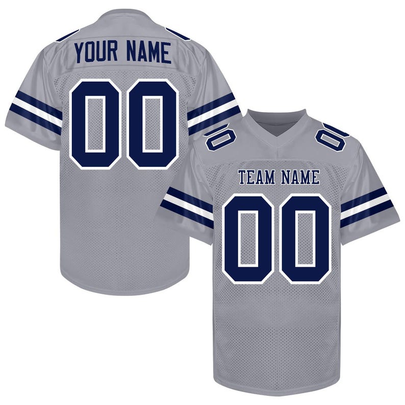 Puede incluir: Camiseta de f&uacute;tbol gris con detalles en azul marino y el n&uacute;mero "00". La camiseta tiene el texto "YOUR NAME" en la espalda y "TEAM NAME" en la parte delantera. Ribetes blancos delinean los n&uacute;meros y rayas en azul marino.
