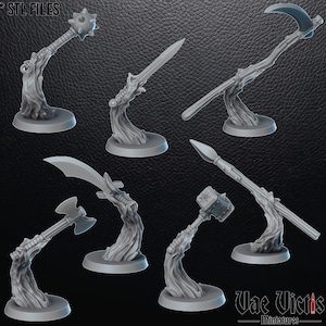 Puede incluir: Colección de miniaturas de armas grises, incluyendo una maza, espada, guadaña, hacha, lanza y martillo. Cada arma está montada sobre una base estilizada. El texto "* STL FILES" está en la esquina superior izquierda y "Vae Victis - miniatures" en la inferior derecha.