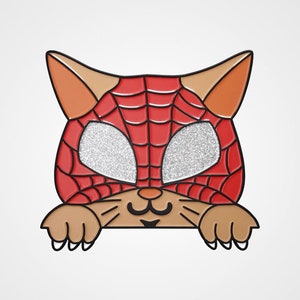 May include: A cat-shaped pin with a red and black spiderweb mask and glittery silver eye coverings. The cat's ears and paws are tan, and the pin has a black outline. The pin is a fun accessory for cat lovers and comic book fans.