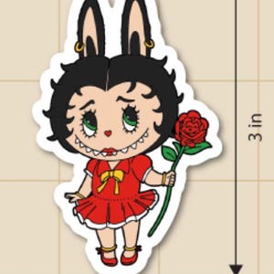 May include: A die-cut sticker featuring a cartoon character with black hair and bunny ears, wearing a red dress and holding a red rose. The sticker is 3 inches tall and 1.9 inches wide.