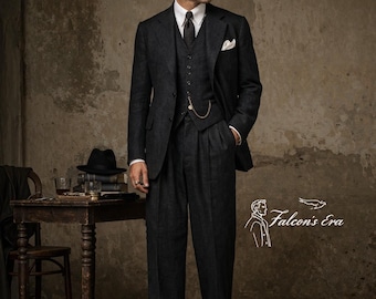 Può includere: Un abito a tre pezzi grigio scuro con camicia bianca e cravatta nera. L'abito comprende giacca, gilet e pantaloni a pieghe. È visibile una catena dell'orologio da taschino. È presente anche il testo "Falcon's Era".
