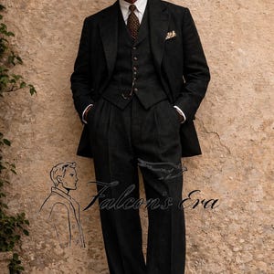 Puede incluir: Un traje de tres piezas gris oscuro con un sombrero de paja. El traje incluye chaqueta, chaleco y pantalón con pliegues. Una corbata estampada y un pañuelo de bolsillo añaden detalles. Se ve el texto "Falcon's Era".
