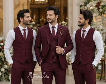 May include: Three individuals wearing matching burgundy three-piece suits consisting of a blazer, a button-down vest, and trousers, paired with a white dress shirt and a burgundy tie. The center suit features a gold pocket watch chain and a floral lapel pin.