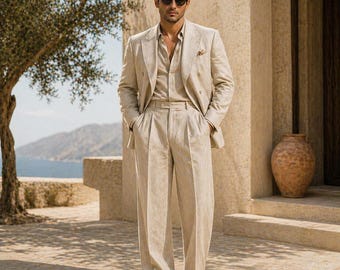 May include: A light beige linen suit, comprising a double-breasted blazer, shirt, and pleated trousers. The suit is worn with brown leather shoes. The person is wearing sunglasses and standing outdoors near a tree and a large vase.
