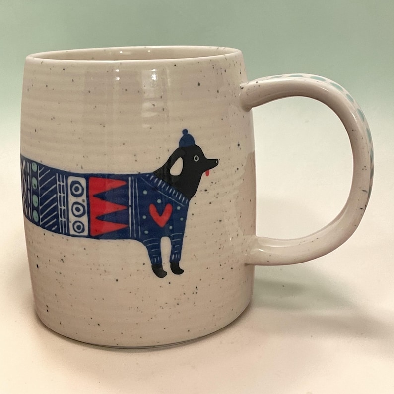 May include: A white ceramic mug with a black handle and the text "But First, Coffee" in a handwritten style. The mug is on a white surface. The mug is 4 inches tall.