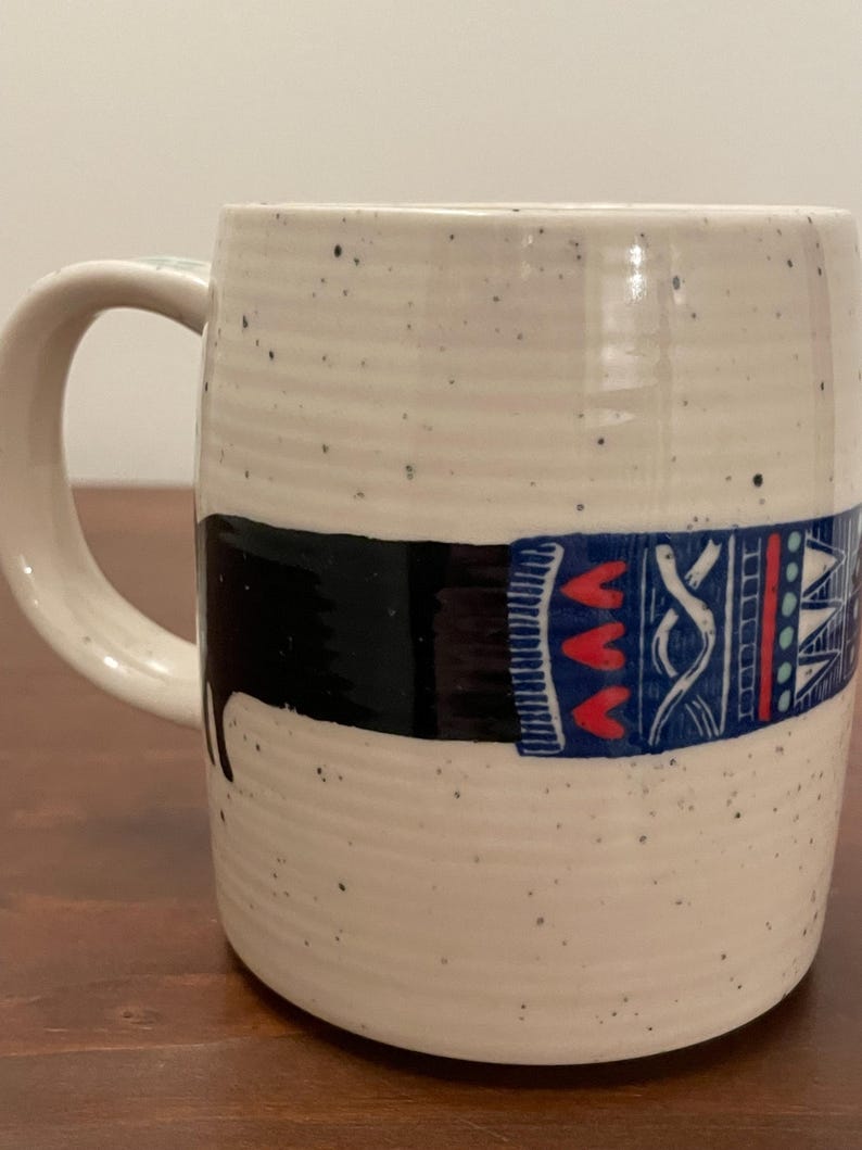 May include: A set of three ceramic mugs with a speckled, matte finish. The mugs are in shades of cream, light gray, and dark gray. Each mug has a simple, minimalist design and a rounded handle. Perfect for coffee or tea.