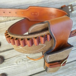 May include: A brown leather gun belt with a holster and a suede lining. The belt has a row of loops for bullets.
