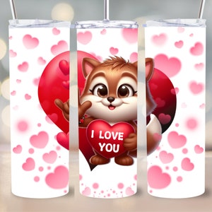 Könnte beinhalten: Ein weißer Becher mit einem Cartoon-Fuchs, der ein rotes Herz mit der Aufschrift "I LOVE YOU" hält. Der Becher hat einen roten Herz-Hintergrund und rosa Herzen, die über die Oberfläche verstreut sind. Ein silberner Strohhalm und Deckel sind enthalten.