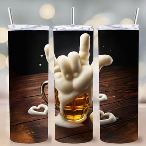 Könnte beinhalten: Ein schwarzer Becher mit weißem Deckel und Strohhalm, der ein Bier-Thema-Design zeigt. Das Design umfasst einen Bierkrug mit einer Handgeste aus Schaum und Schaumherzen auf einer Holzoberfläche. Der Becher ist für kalte Getränke konzipiert.