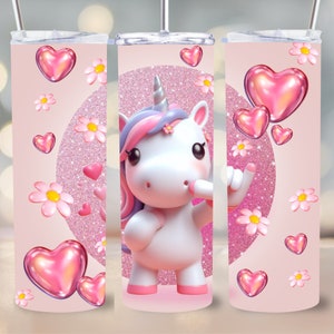 Könnte beinhalten: Ein rosa Becher mit einem Cartoon-Einhorn-Design. Das Einhorn hat eine rosa und lila Mähne und ein silbernes Horn. Das Design umfasst rosa Herzen, weiße Gänseblümchen und einen glitzernden rosa Hintergrund. Er hat einen silbernen Strohhalm und Deckel.