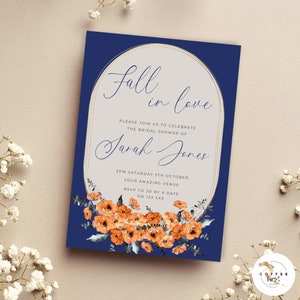 K&ouml;nnte beinhalten: Eine marineblaue Einladung zur Bridal Shower mit einem goldenen ovalen Rahmen. Der Text im Rahmen lautet "Fall in love" und "Bitte feiern Sie mit uns die Bridal Shower von Sarah Jones". Die Einladung enth&auml;lt auch das Datum, die Uhrzeit und den Ort der Shower. Der untere Teil der Einladung zeigt eine Aquarell-Illustration von orangefarbenen Blumen.