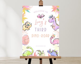 May include: Welcome to Lucy's Third Dino-Roar, a colorful party sign with a pink bow, dinosaurs, and the date 20 November 2023.
