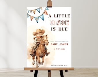 May include: A white sign with a watercolor illustration of a little cowboy riding a horse. The sign says "A Little Cowboy is Due" with the date "16 Nov 202X" and the text "Thank you for celebrating Baby Jones".