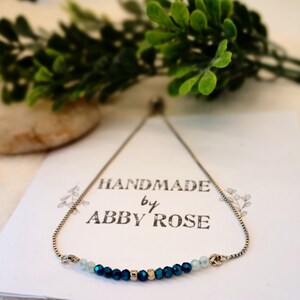 Teal, dark blue, and silver bead bracelet on a silver adjustable slider chain