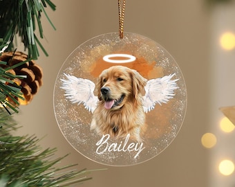 May include: A round, clear glass ornament with a golden halo and white angel wings. A golden retriever dog with the name "Bailey" is featured in the center. The ornament is perfect for remembering a beloved pet.