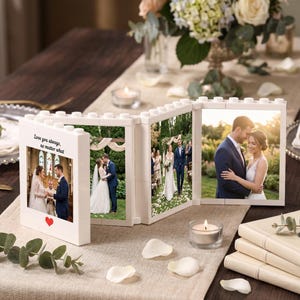 May include: A white, modular, brick-style folding photo frame displaying four wedding photographs. The first panel features the text 'Love you always, no matter what' above a small red heart. The frame is constructed with interlocking studs.