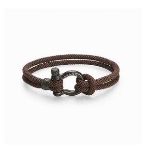 May include: A brown rope bracelet with a black metal clasp. The clasp has the word "SVANA" engraved on it.