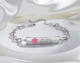 May include: Silver medical alert bracelet with pink accents. The bracelet has a rectangular tag that reads "Type 1 Diabetes Insulin Dependent ICE: 801-123-4567" and features a pink medical symbol.