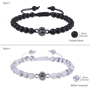 May include: Two styles of beaded bracelets with a small, round, silver-toned charm in the center. The first bracelet has black beads and the second bracelet has white beads with black marbling. The text "6mm Diameter" is next to a close-up of a bead from each bracelet. The text "Frosted Stone" is below the first bracelet and the text "White Turquoise" is below the second bracelet.
