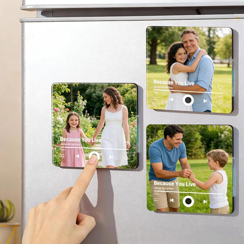 May include: Rectangular photo magnets with family photos, resembling music player interfaces. Each magnet displays a different family photo with the text "Because You Live" and artist information. The magnets are attached to a metallic surface.