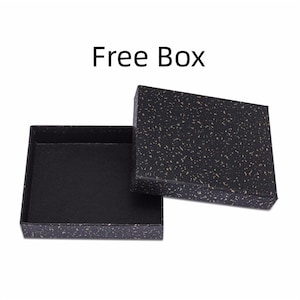 May include: An open black box with a speckled pattern and a matching lid. The box is empty and sits on a white background. The text "Free Box" is above the box.