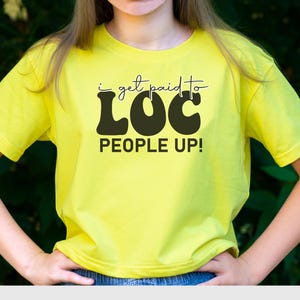 May include: A yellow t-shirt with the text "i get paid to LOC PEOPLE UP!" in black and white lettering.