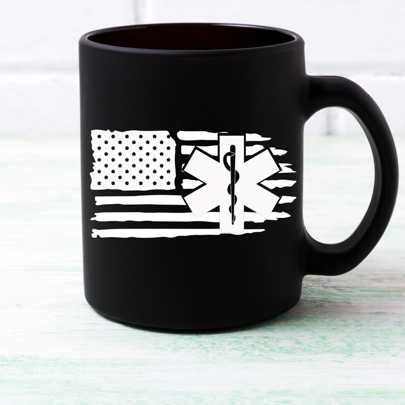 May include: Black matte ceramic coffee mug with a white distressed American flag design and a white medical symbol with a snake and staff.