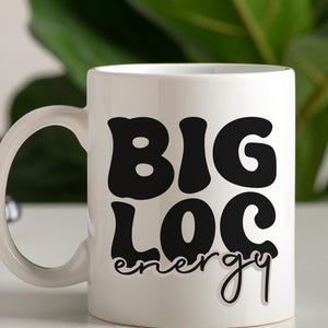 May include: White ceramic mug with a black graphic that says "BIG LOC energy" in a retro font.