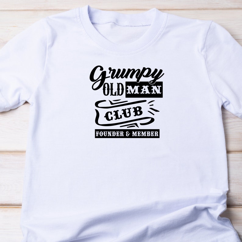 May include: White t-shirt with black text that reads "Grumpy Old Man Club Founder & Member".