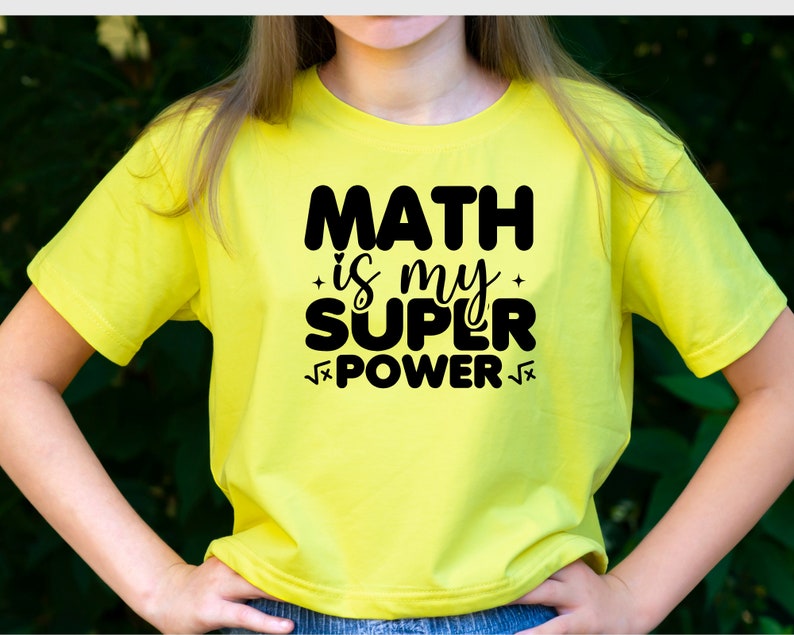 Puede incluir: Una camiseta amarilla con texto negro que dice "MATH is my SUPER POWER" con un s&iacute;mbolo de ra&iacute;z cuadrada antes y despu&eacute;s de la palabra "POWER".