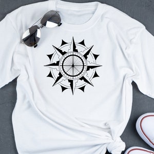 May include: White t-shirt with a black compass design printed on the front.