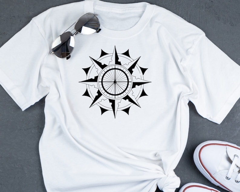 May include: White t-shirt with a black compass design printed on the front.