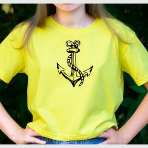 May include: A yellow t-shirt with a black anchor graphic. The anchor is drawn in a nautical style with a rope wrapped around it.