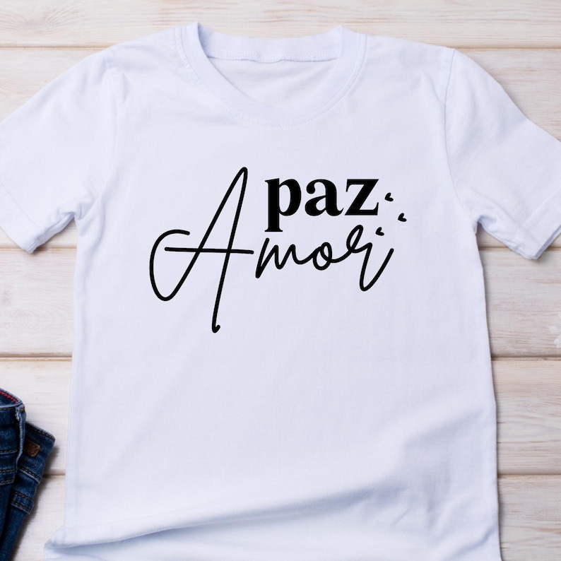 May include: White t-shirt with black text that reads "A paz... Amor".