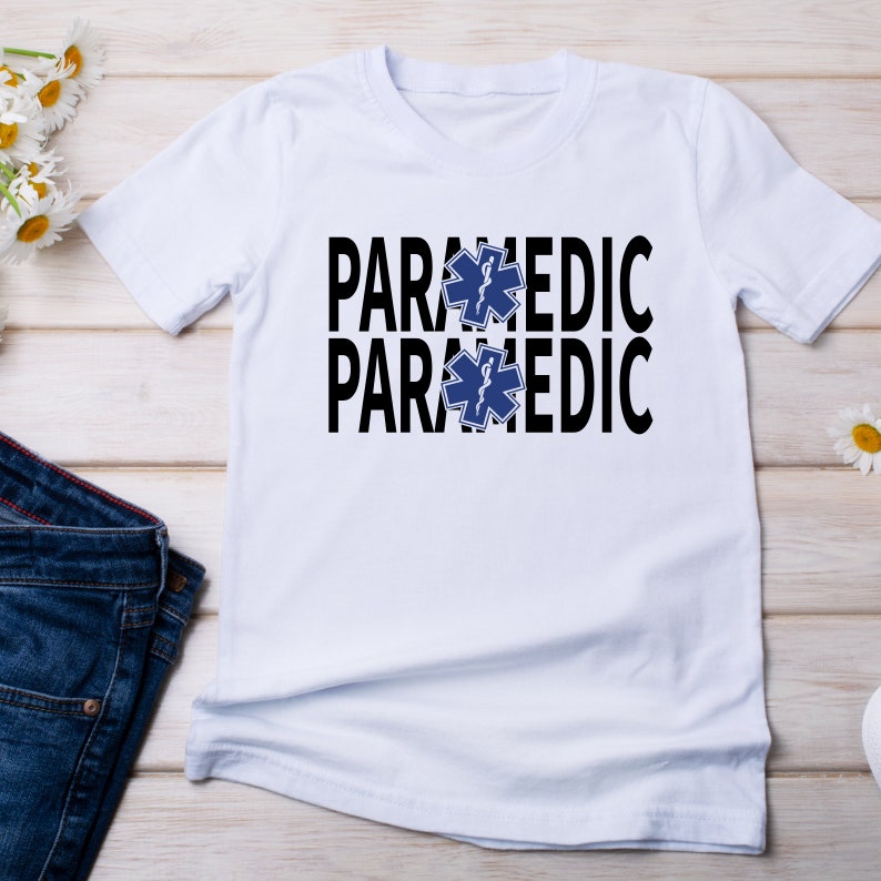 May include: White t-shirt with the words "PARAMEDIC" printed twice in black, with a blue star of life symbol between the words.