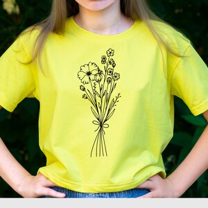 May include: A yellow t-shirt with a black line drawing of a bouquet of flowers.