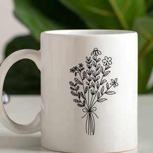 May include: White ceramic mug with a black line drawing of a bouquet of flowers. The flowers are stylized and have simple lines.
