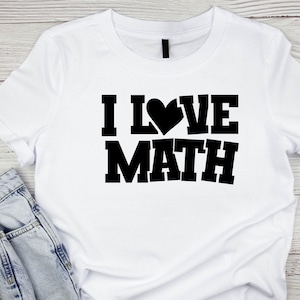 Puede incluir: Camiseta blanca con texto negro que dice "ME ENCANTA LAS MATEM&Aacute;TICAS" con un coraz&oacute;n que reemplaza la "O".