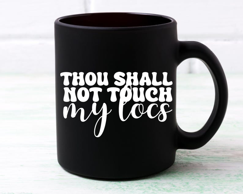 May include: Black ceramic coffee mug with white text that reads "Thou Shall Not Touch My Locs".