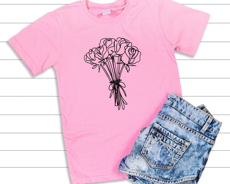May include: A pink t-shirt with a black line drawing of a bouquet of roses.