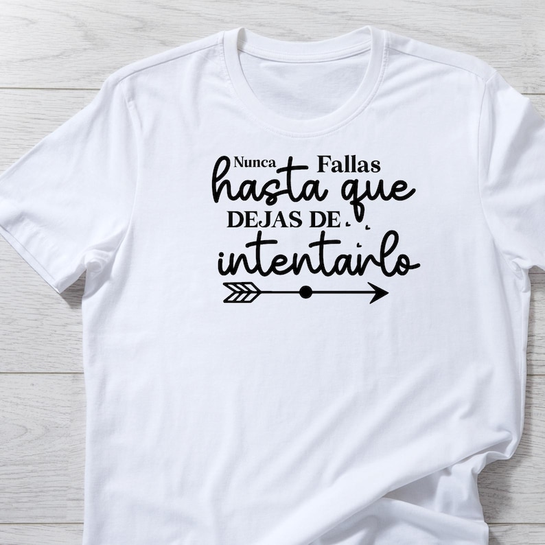 May include: White t-shirt with a black graphic that says "Nunca Fallas hasta que DEJAS DE. intentarlo" with an arrow pointing to the right.