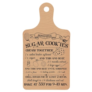 Pode incluir: Uma t&aacute;bua de cortar de madeira castanho com uma receita para biscoitos de a&ccedil;&uacute;car caseiros. A receita inclui ingredientes como manteiga, a&ccedil;&uacute;car, extrato de baunilha, ovos, farinha, fermento em p&oacute; e sal. A t&aacute;bua tem uma pega e um design decorativo.