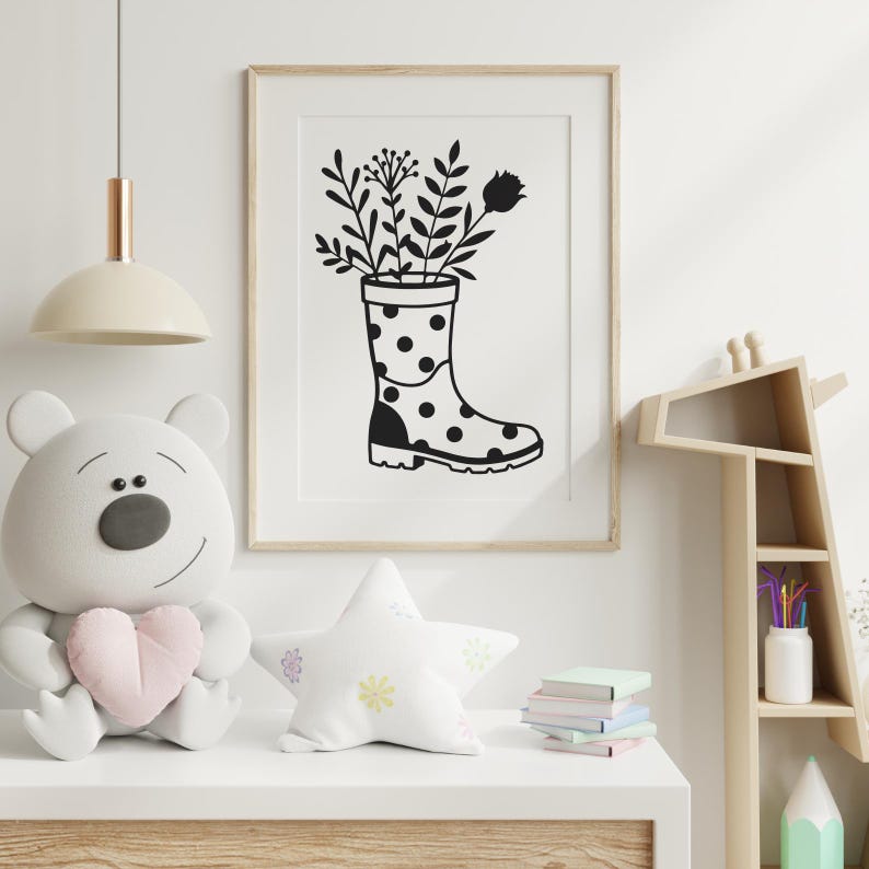 May include: Framed monochrome art print. The image shows a wellington boot with black polka dots, filled with botanical illustrations. The print is in a light wood frame, suitable for a nursery or children's room.