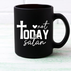 May include: Black ceramic coffee mug with a white cross, heart, and the text "not TODAY satan".