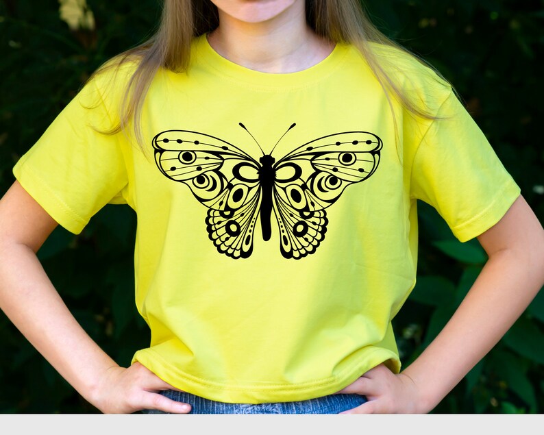May include: A yellow t-shirt with a black butterfly graphic. The butterfly has intricate details and a geometric design.