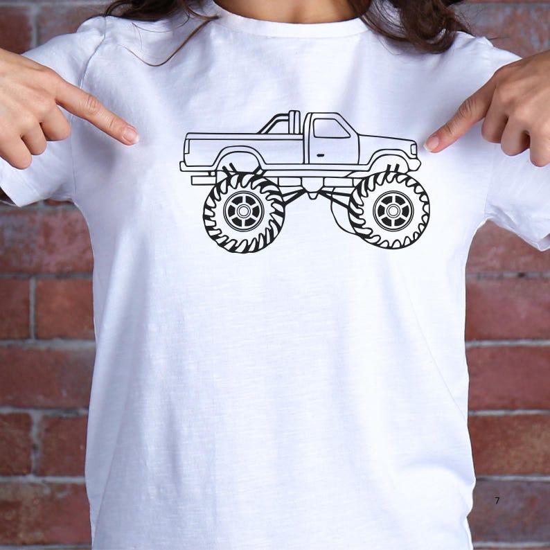 May include: A white t-shirt with a black line drawing of a monster truck. The truck has large tires and a pickup truck bed.