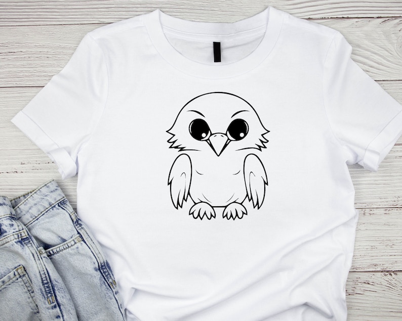 May include: White t-shirt with a black and white cartoon illustration of an owl with large eyes.