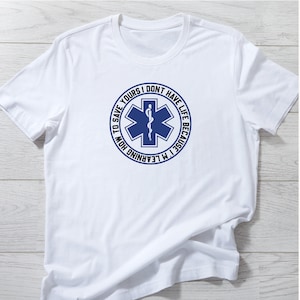 May include: White t-shirt with a blue circle graphic featuring a medical symbol and the text "I'm learning how to save yours, I don't have life because..."