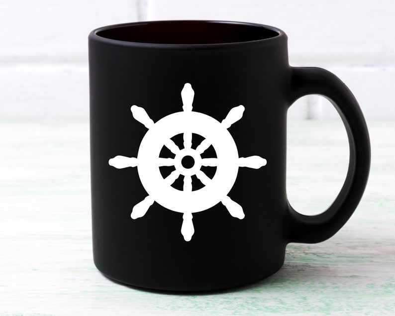May include: Black ceramic coffee mug with a white ship's wheel design.