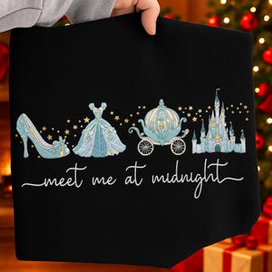 May include: Black fabric featuring a Cinderella theme. The design includes a blue high-heeled shoe, a ball gown, a carriage, and a castle, all in shades of blue and gold. The words "meet me at midnight" are written in cursive.